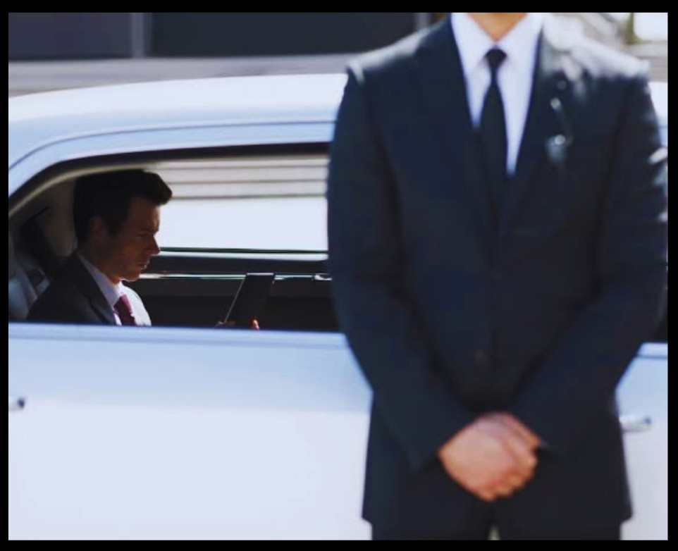Personal security officer beside a client vehicle